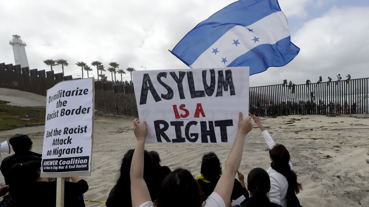 Migrants and their supporters gathered at the border fencing between California and Tijuana.