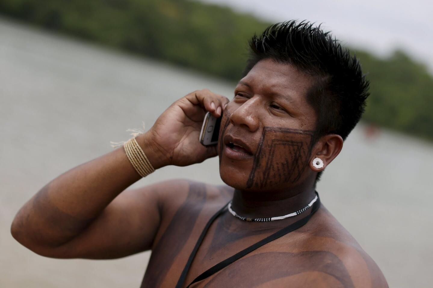 A indigenous man speaks in his cellphone on the river bank during the first World Games for Indigenous Peoples in Palmas