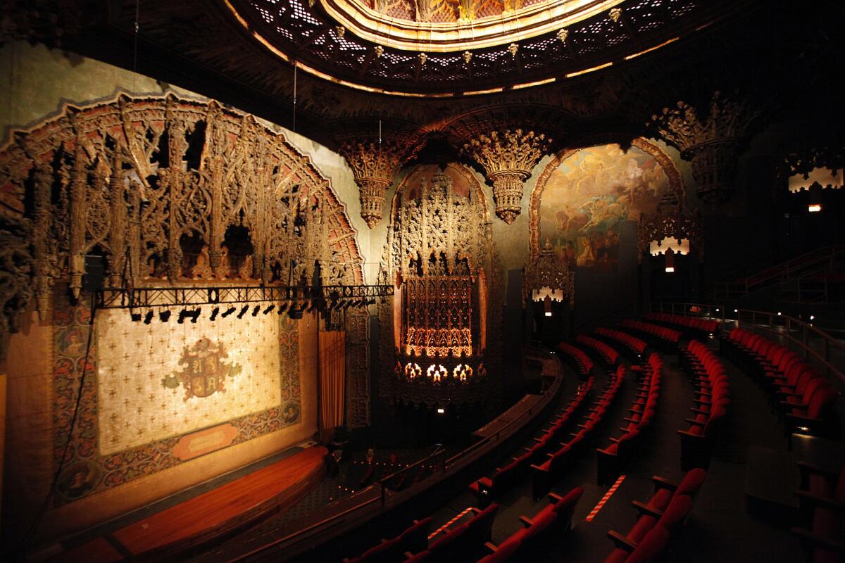 The stage curtain and elaborate proscenium arch surrounding the stage opening and ceiling of the United Artists Theater in the Ace Hotel Hotel and Theater building at 937 S. Broadway in downtown Los Angeles on Feb. 07, 2014.