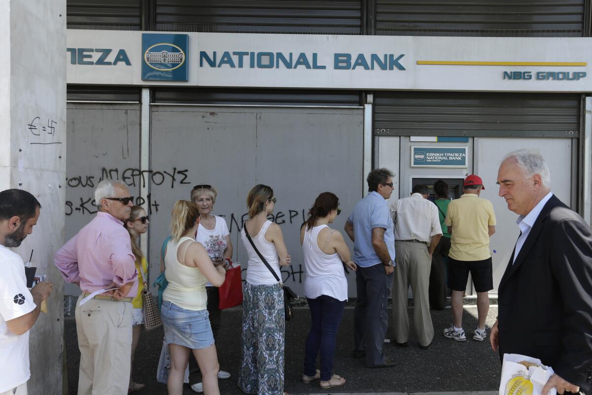 People line up to use ATM machines in Athens on Monday.