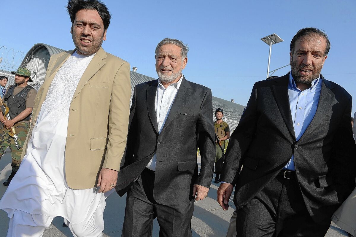 The chief of the Afghan Independent Election Commission, Ahmad Yousuf Nouristani, center, heads to a news conference in Kabul on July 13.