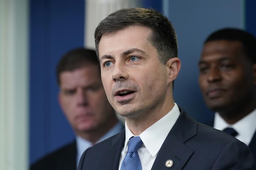 FILE - Transportation Secretary Pete Buttigieg, center, speaks during a briefing at the White House in Washington, May 16, 2022, as Labor Secretary Marty Walsh, left, and Environmental Protection Agency administrator Michael Regan, right, listen. The Biden administration is saying the U.S. economy would face a severe economic shock if senators don't pass legislation this week to avert a rail worker strike. Walsh and Buttigieg are meeting with Democratic senators Thursday, Dec. 1, to underscore that rail companies will begin shuttering operations well before a potential strike begins on Dec. 9. (AP Photo/Susan Walsh, File)