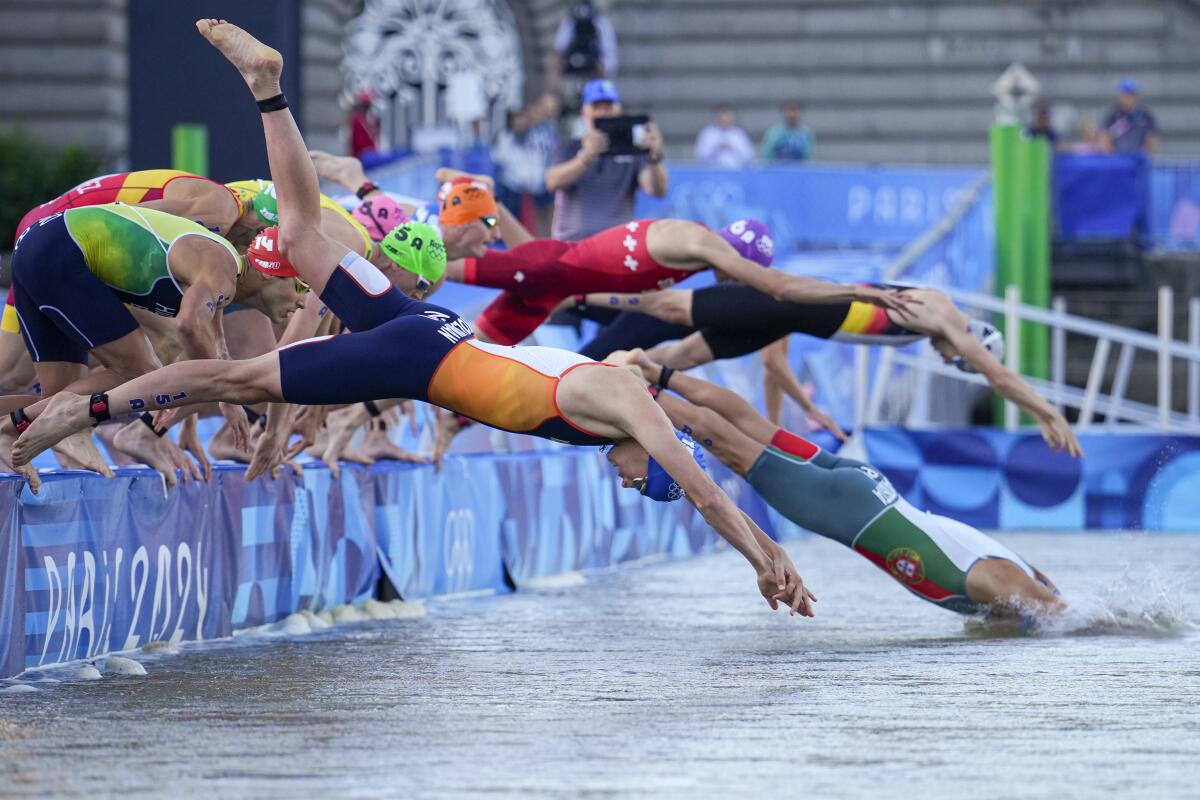 Mitch Kolkman of the Netherlands dives into the water for the start of the mixed relay triathlon at the Paris Olympic Games.