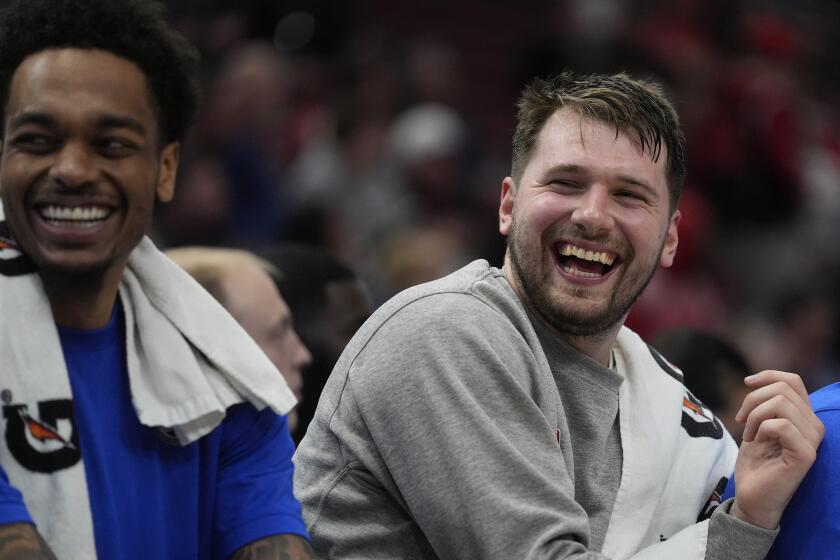 Dallas Mavericks guard Luka Doncic, right, laughs on the bench during the second half of an NBA basketball game against the Chicago Bulls, Monday, March 11, 2024, in Chicago. (AP Photo/Erin Hooley)