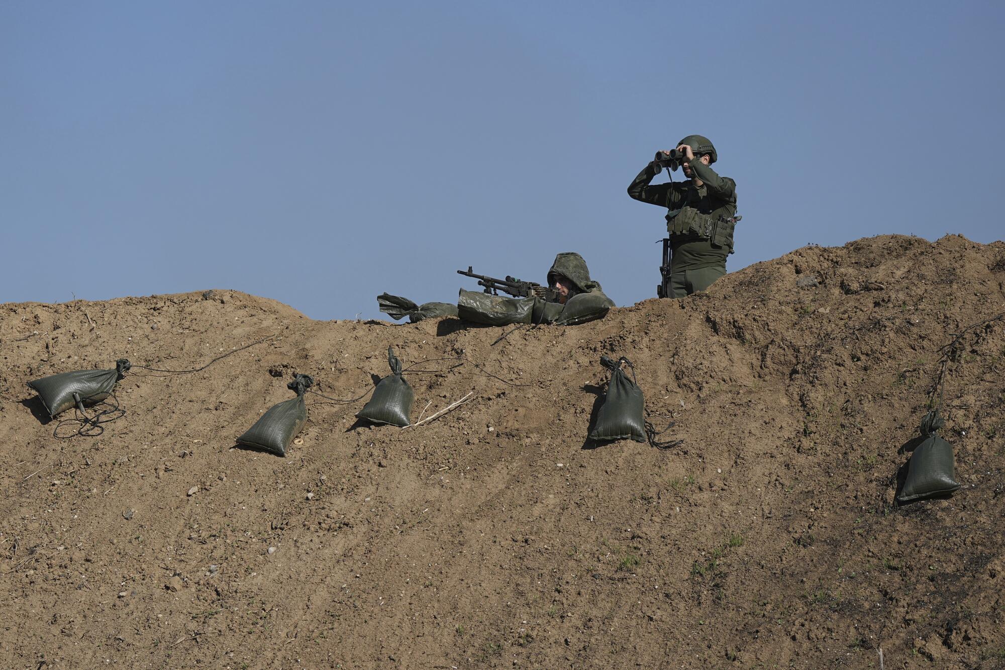 Soldiers in southern Israel looking into Gaza over the border