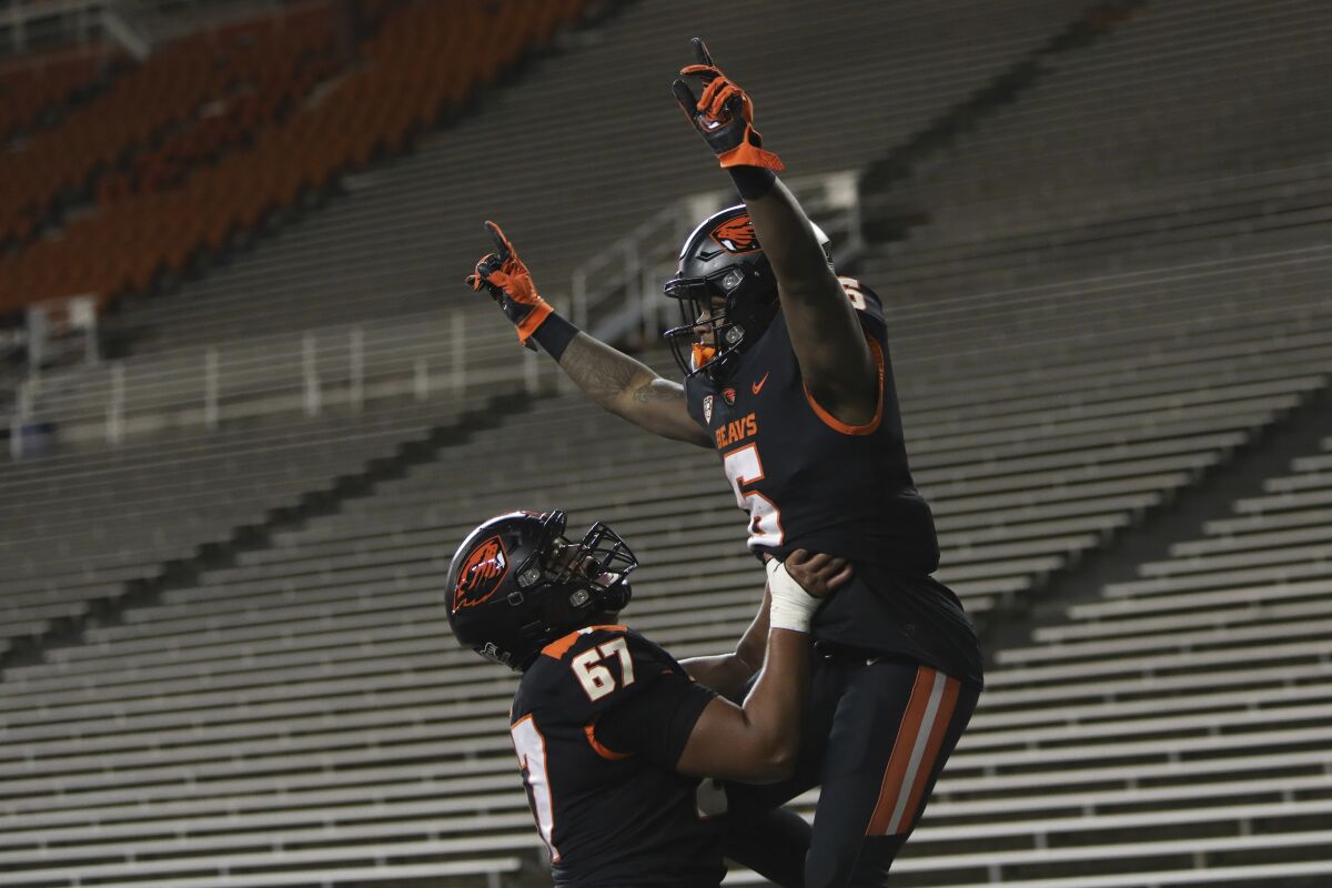 Oregon State offensive linesman Joshua Gray (67) lifts Oregon State running back Jermar Jefferson (6) into the air after Jefferson scored a touchdown during the second half of an NCAA college football game against Washington State in Corvallis, Ore., Saturday, Nov. 7, 2020. Washington State won 38-28. (AP Photo/Amanda Loman)