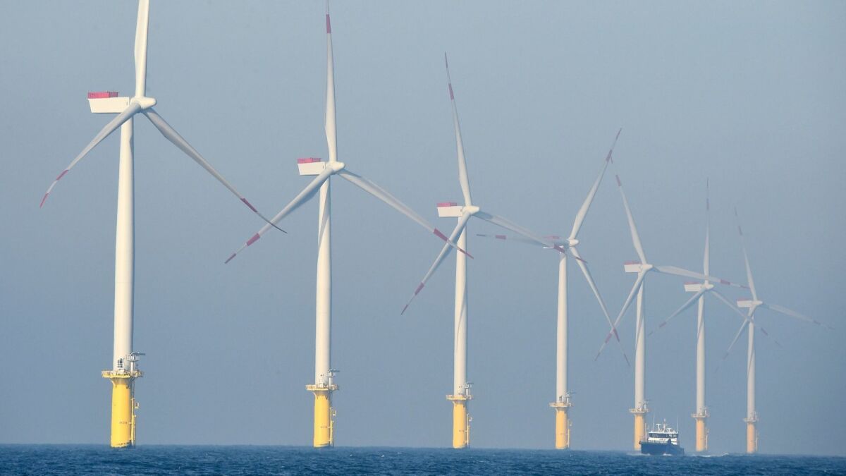 A service vessel passing by the turbines of an offshore wind farm in Germany. Renewable energy sources account for 36 percent of Germany's power mix.