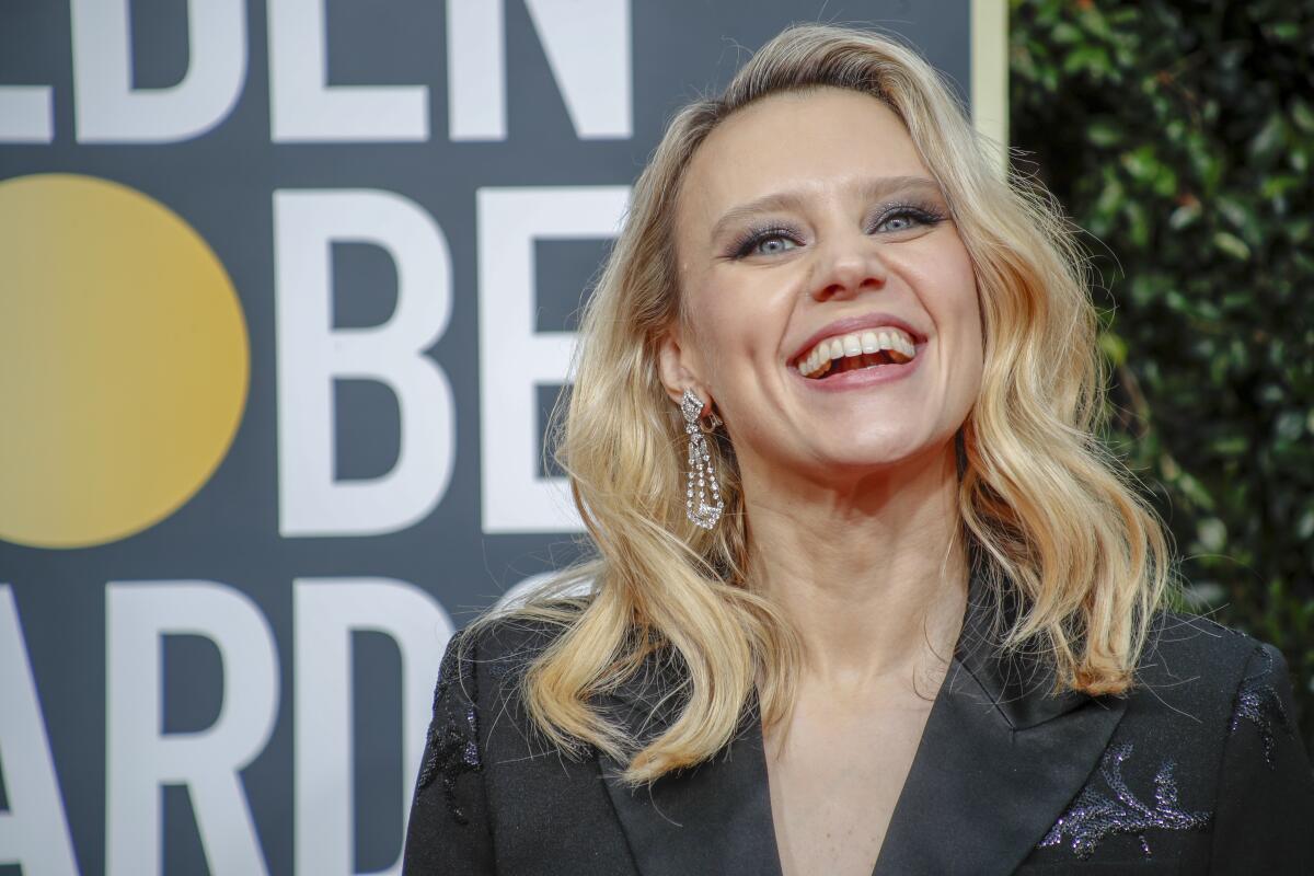 Kate McKinnon smiles while standing at the Golden Globe Awards