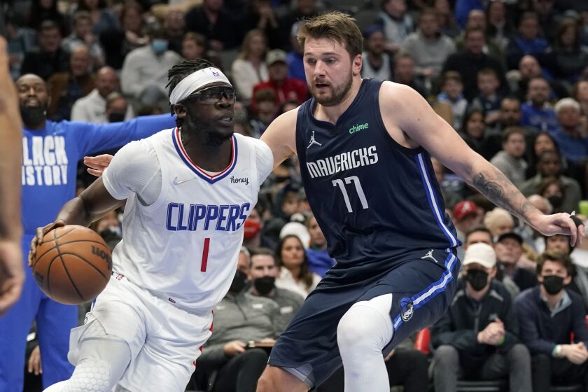 The Clippers' Reggie Jackson drives against the Dallas Mavericks' Luka Doncic on Feb. 12, 2022.