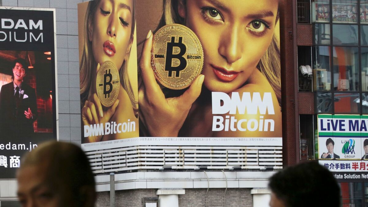 A huge advertisement for bitcoin is displayed near a train station in Tokyo. Bitcoin and other cryptocurrencies offer shadowy tales for writers and filmmakers.