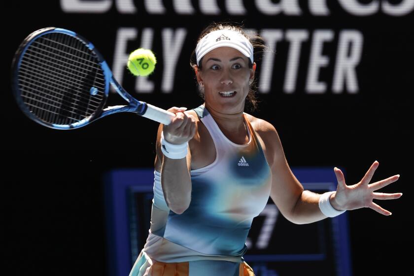 Garbine Muguruza of Spain plays a forehand return to Alize Cornet of France during their second round match at the Australian Open tennis championships in Melbourne, Australia, Thursday, Jan. 20, 2022. (AP Photo/Hamish Blair)
