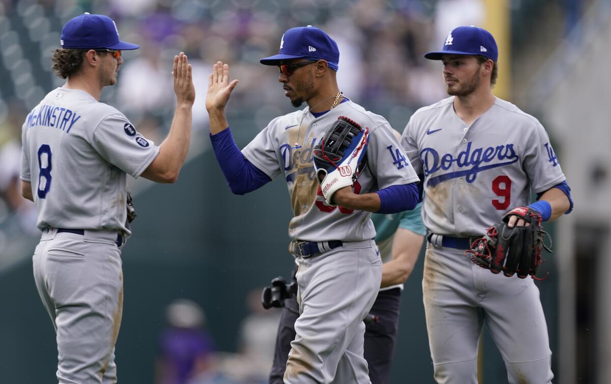 Dodgers second baseman Zach McKinstry celebrates with right fielder Mookie Betts and shortstop Gavin Lux.