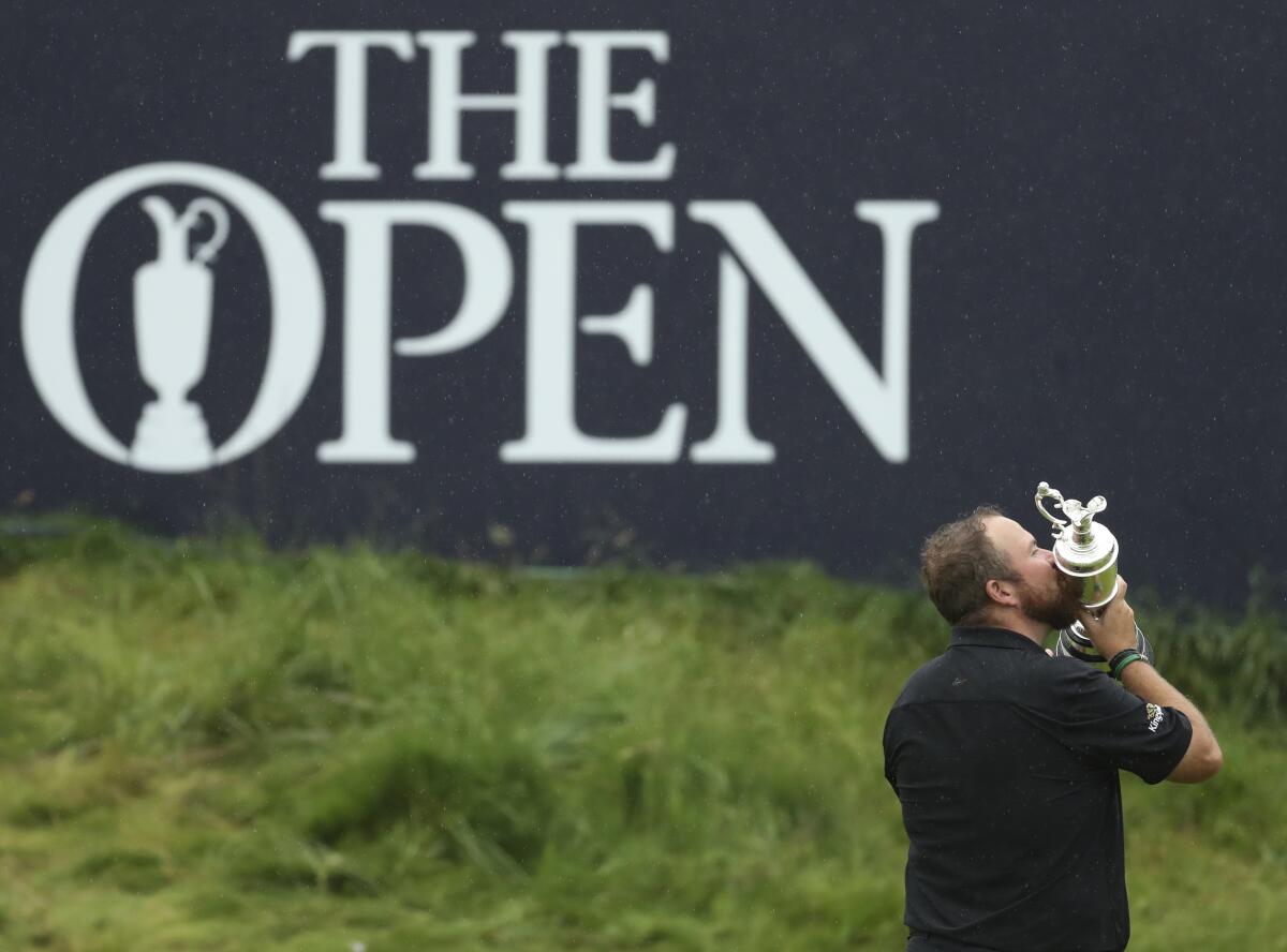 FILE - In this Sunday, July 21, 2019 file photo, Ireland's Shane Lowry holds and kisses the Claret Jug trophy on the 18th green as he poses for the crowd and media after winning the British Open Golf Championships at Royal Portrush in Northern Ireland. The British Open is heading back to Royal Portrush. The R&A says the world’s oldest major championship will return to the Northern Irish venue in 2025 after a successful staging of the British Open there in 2019 when Irish player Shane Lowry won by six shots. That marked the first time Royal Portrush had hosted the event since 1951. (AP Photo/Peter Morrison, File)