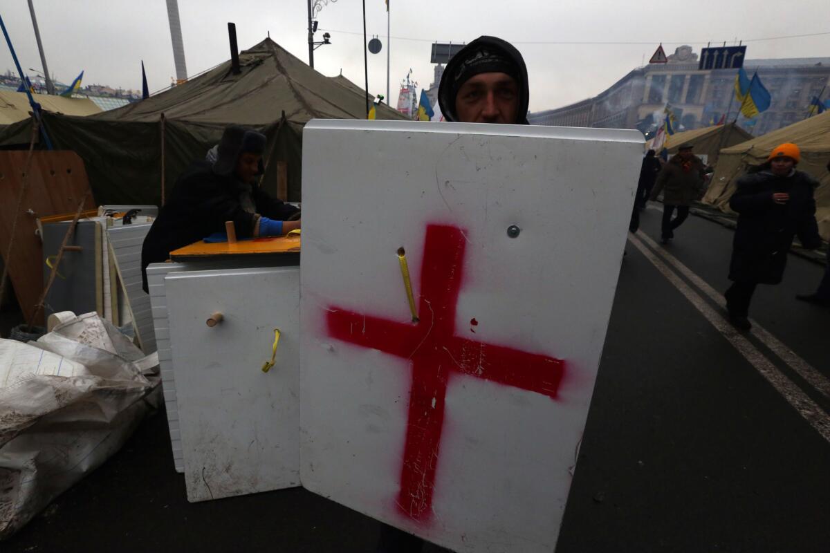 A Ukrainian protester displays a new shield at the opposition camp in Kiev's Independence Square.