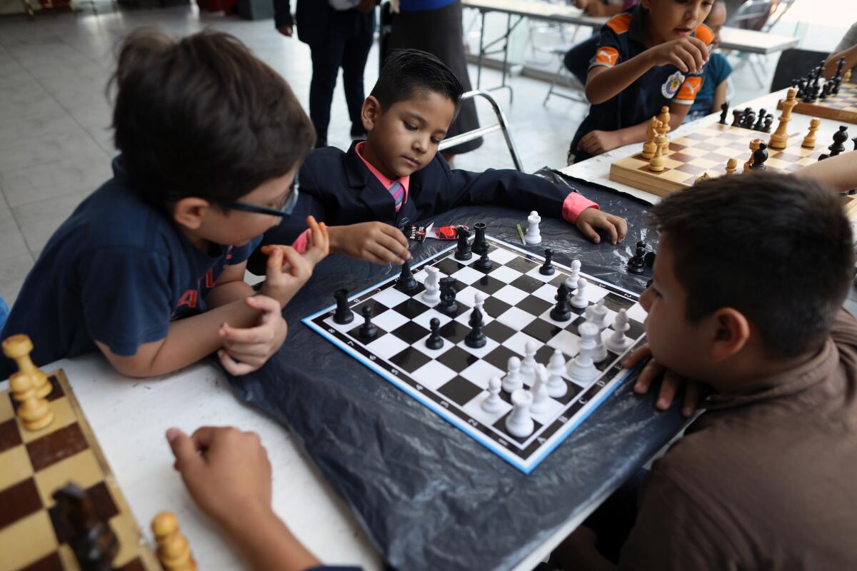 Adoniram Enriquez, 8, second from left, along with other members of La Luz del Mundo play chess at the church's Cultural and Recreation Center in the Hermosa Provincia neighborhood . (Gary Coronado / Los Angeles Times)