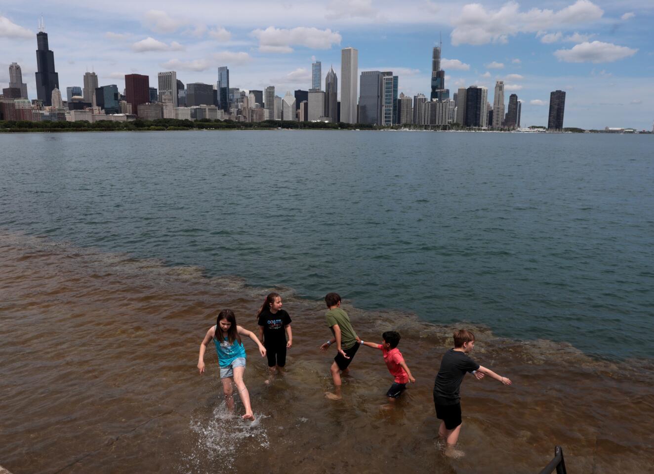 Siblings and cousins play in the flooded embankment as Lake Michigan floods over a wide pedestrian embankment at Solidarity Drive just outside the Adler Planetarium in Chicago, June 5, 2019.