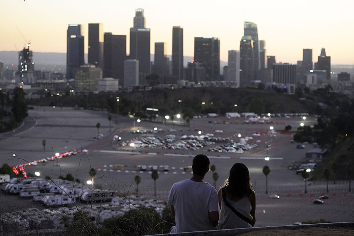 Visitors watch the sunset over the COVID-19 vaccination site at Dodger Stadium.