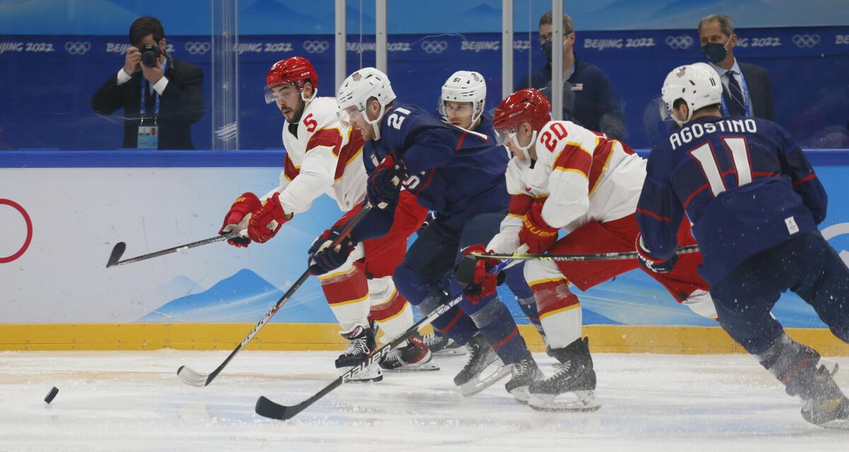 A scrum of U.S. and China players all trying to get to the puck. U.S. Olympic mens ice hockey.