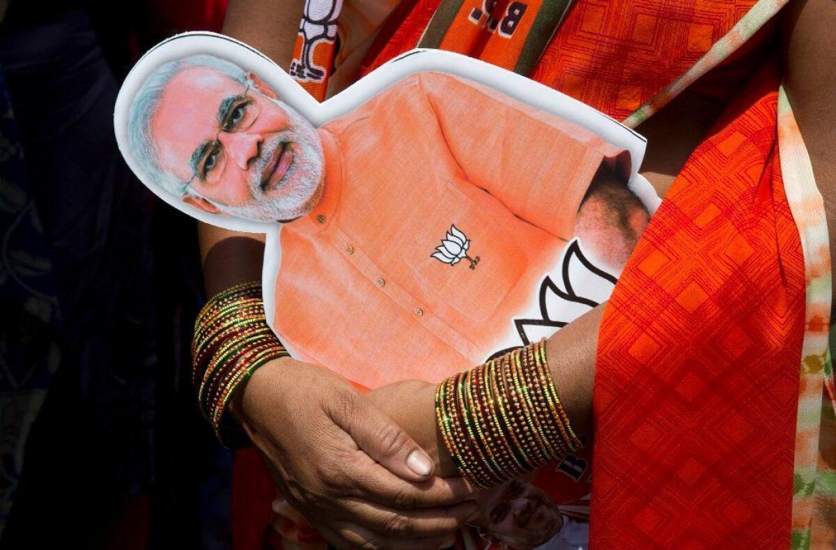 A supporter holds a photograph of Indian Prime Minister Narendra Modi at an election rally in Hyderabad on March 25.