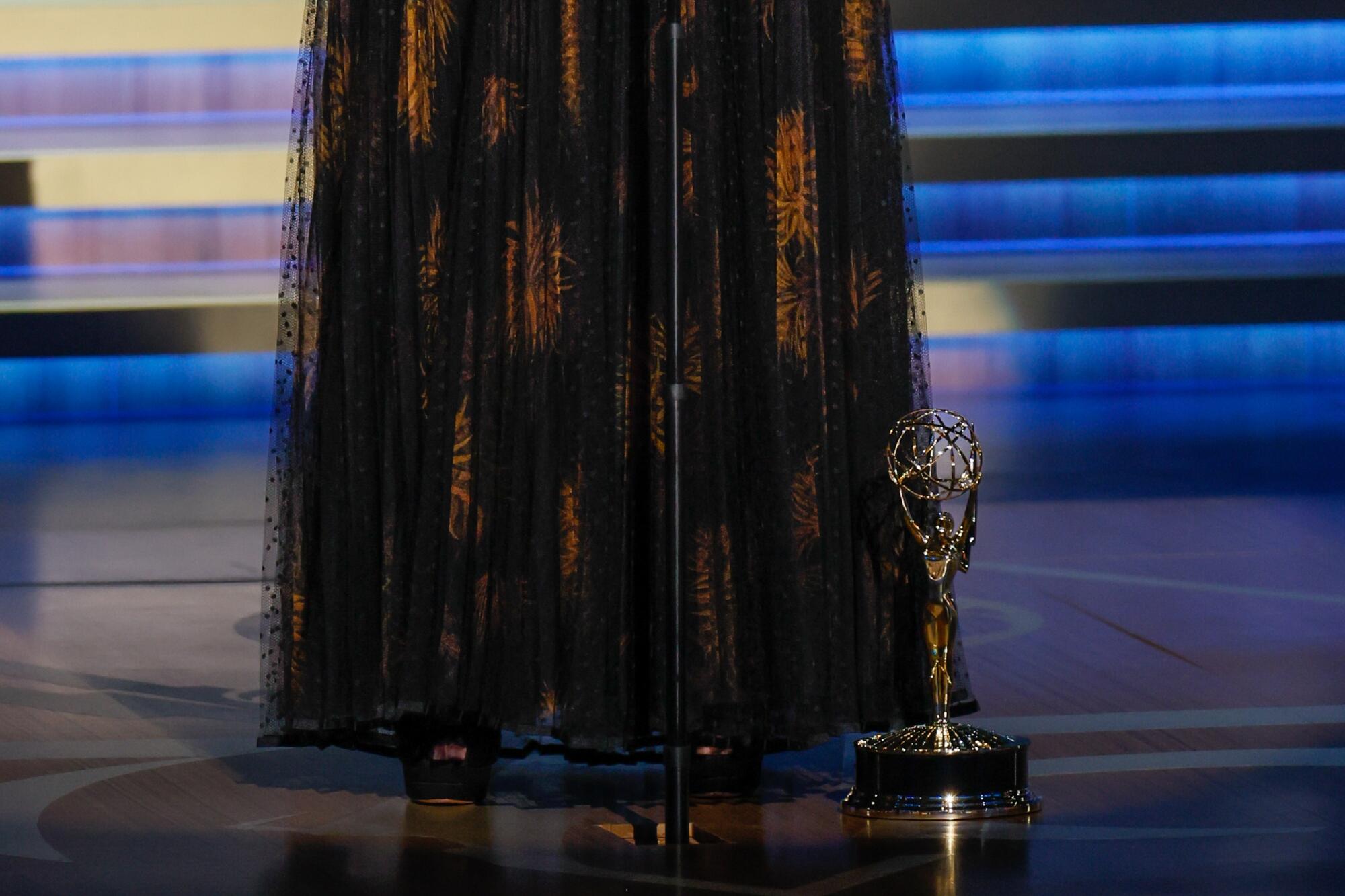 Jennifer Coolidge's Emmy stands at her feet as she gives her speech.