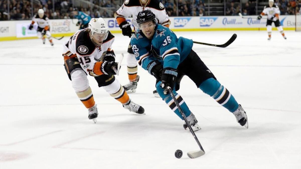 Sharks center Logan Couture reaches for the puck as Ducks defenseman Sami Vatanen pressures him during the second period of a game on March 18.