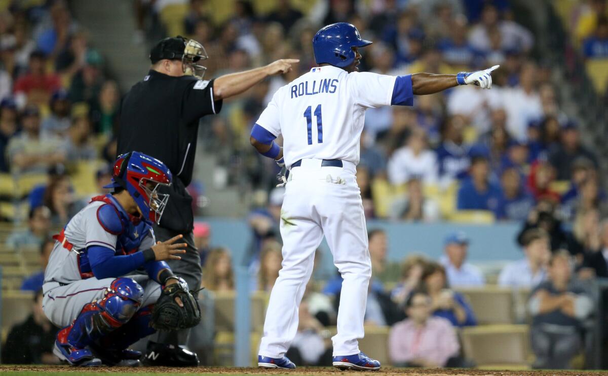 Dodgers shortstop Jimmy Rollins and Umpire Marvin Hudson both point to Texas reliever Keone Kela after a balk in the ninth inning, which brought in the winning run. The Dodgers beat the Rangers, 1-0.