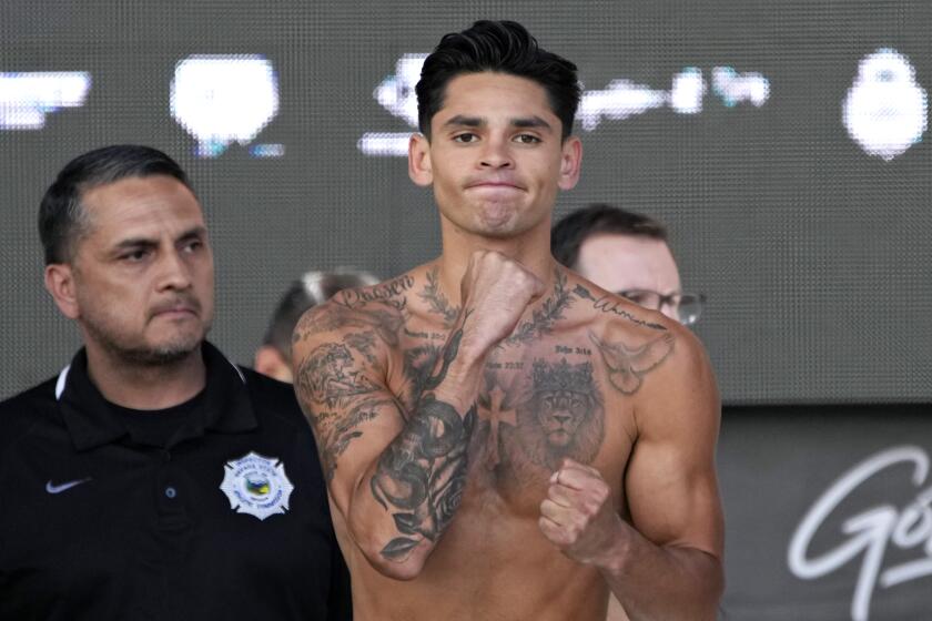 Ryan Garcia poses on the scale during a weigh-in Friday, April 21, 2023, in Las Vegas. Garcia is scheduled to fight Gervonta Davis in a catchweight boxing bout in Las Vegas on Saturday. (AP Photo/John Locher)