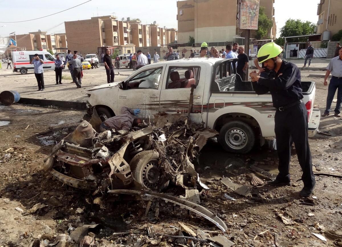 An Iraqi policeman inspects the site of a car bomb attack in Kirkuk.