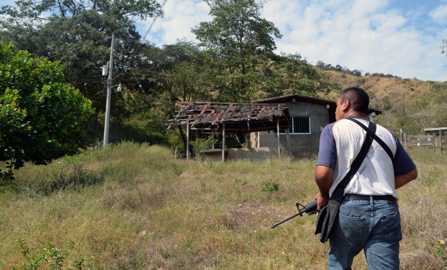 A member of the Mexican federal police inspects an abandoned home during a tour of a ghost pueblo in Tecpan de Galeana, Guerrero state, on Mexico's Pacific Coast. Extortion, threats and killings carried out by a group of heavily armed drug cartel members have emptied out more than 20 small villages in the mountains between the tourist resorts of Acapulco and Ixtapa.