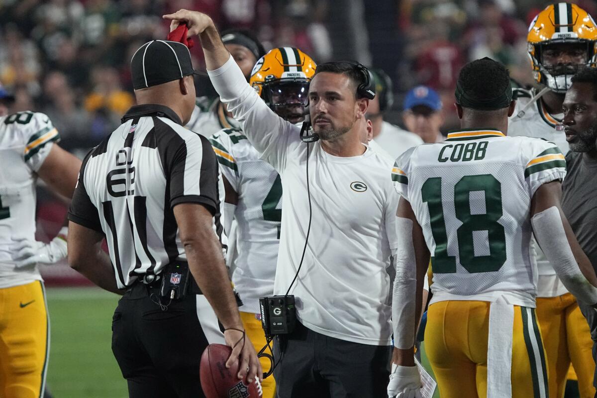 Green Bay Packers head coach Matt LaFleur throws the red flag during the first half of an NFL football game against the Arizona Cardinals, Thursday, Oct. 28, 2021, in Glendale, Ariz. (AP Photo/Rick Scuteri)