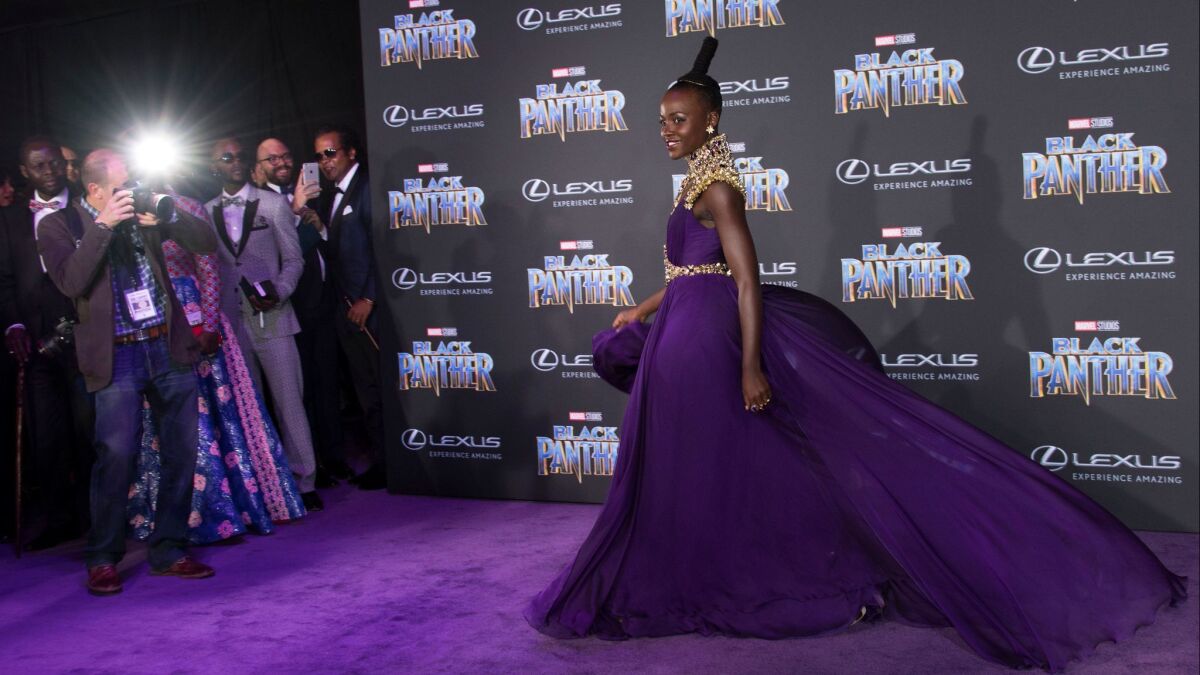 Wearing a custom-made Atelier Versace gown, Lupita Nyong'o poses on the purple carpet for the premiere of Marvel Studios' "Black Panther" on Monday night.