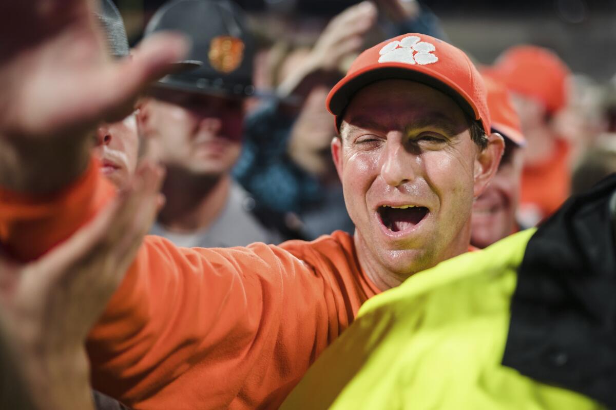 Clemson head coach Dabo Swinney celebrates with fans as he walks off the field after defeating North Carolina State in an NCAA college football game, Saturday, Oct. 1, 2022, in Clemson, S.C. (AP Photo/Jacob Kupferman)