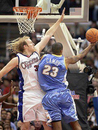 The Clippers' Chris Kaman goes up in attempt to block shot by the Nuggets' Marcus Camby.