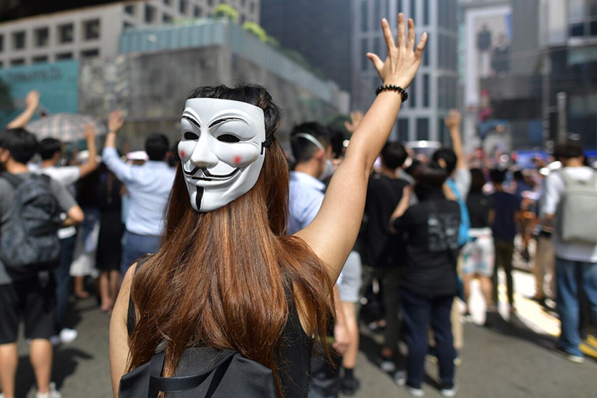 A woman with a Guy Fawkes mask takes part in a protest in Hong Kong on Friday.