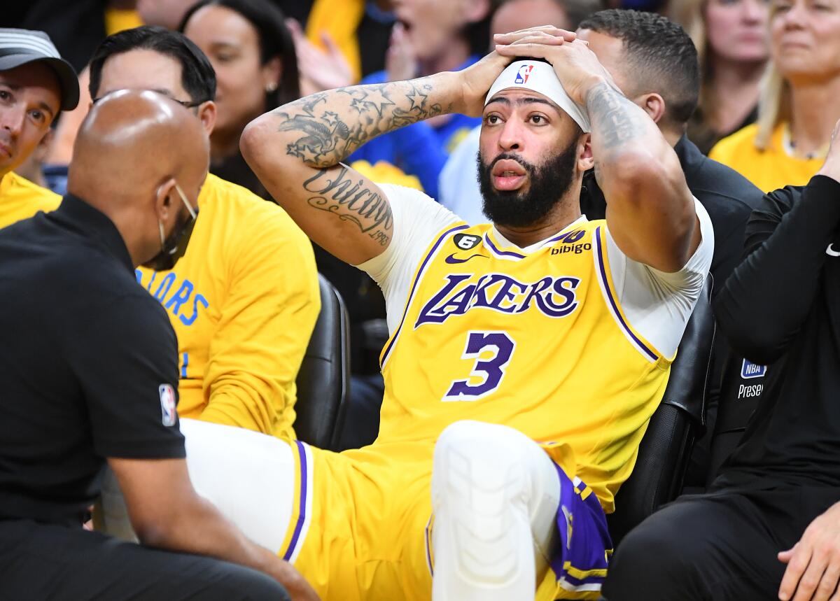 Lakers star Anthony Davis talks to a team trainer after sustaining a head injury against the Golden State Warriors in Game 5.