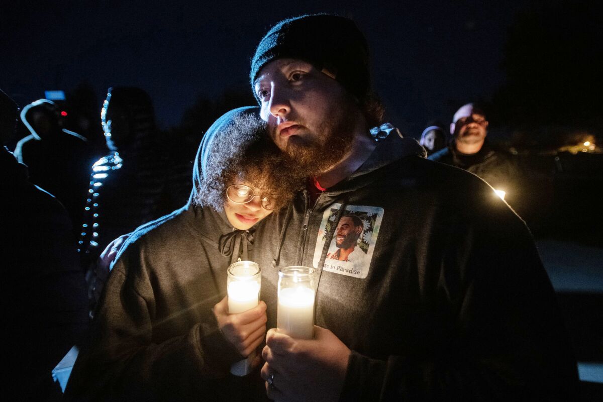 Candlelight illuminates a photo of Tire Nichols on the hoodie worn by a mourner at a vigil in North Natomas.