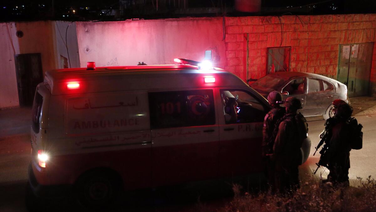 Israeli army soldiers stop an ambulance during a night raid in Yatta, located south of the city of Hebron in the West Bank, on June 15.
