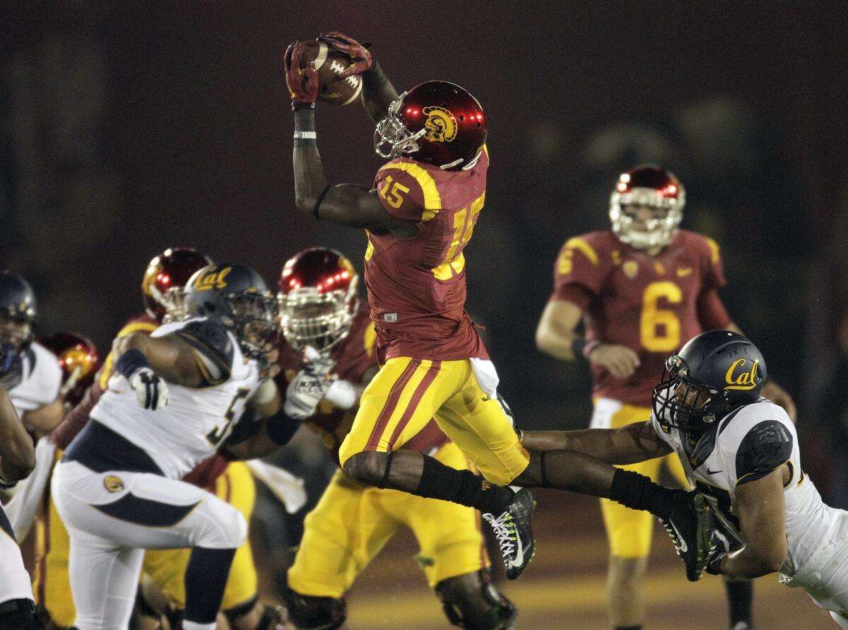 USC receiver Nelson Agholor leaps above California defenders to make a catch during their game at the Coliseum on Nov. 13.