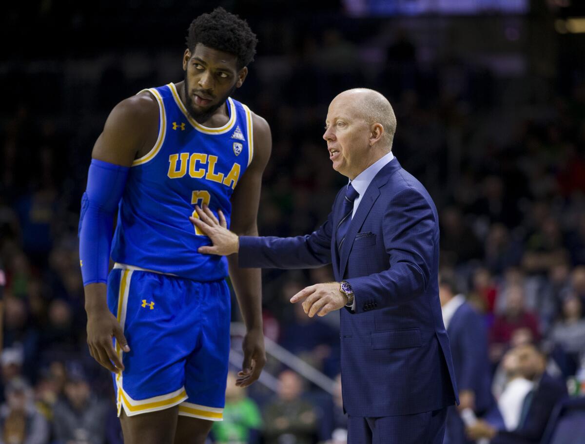 UCLA coach Mick Cronin talks to Cody Riley on the sideline.
