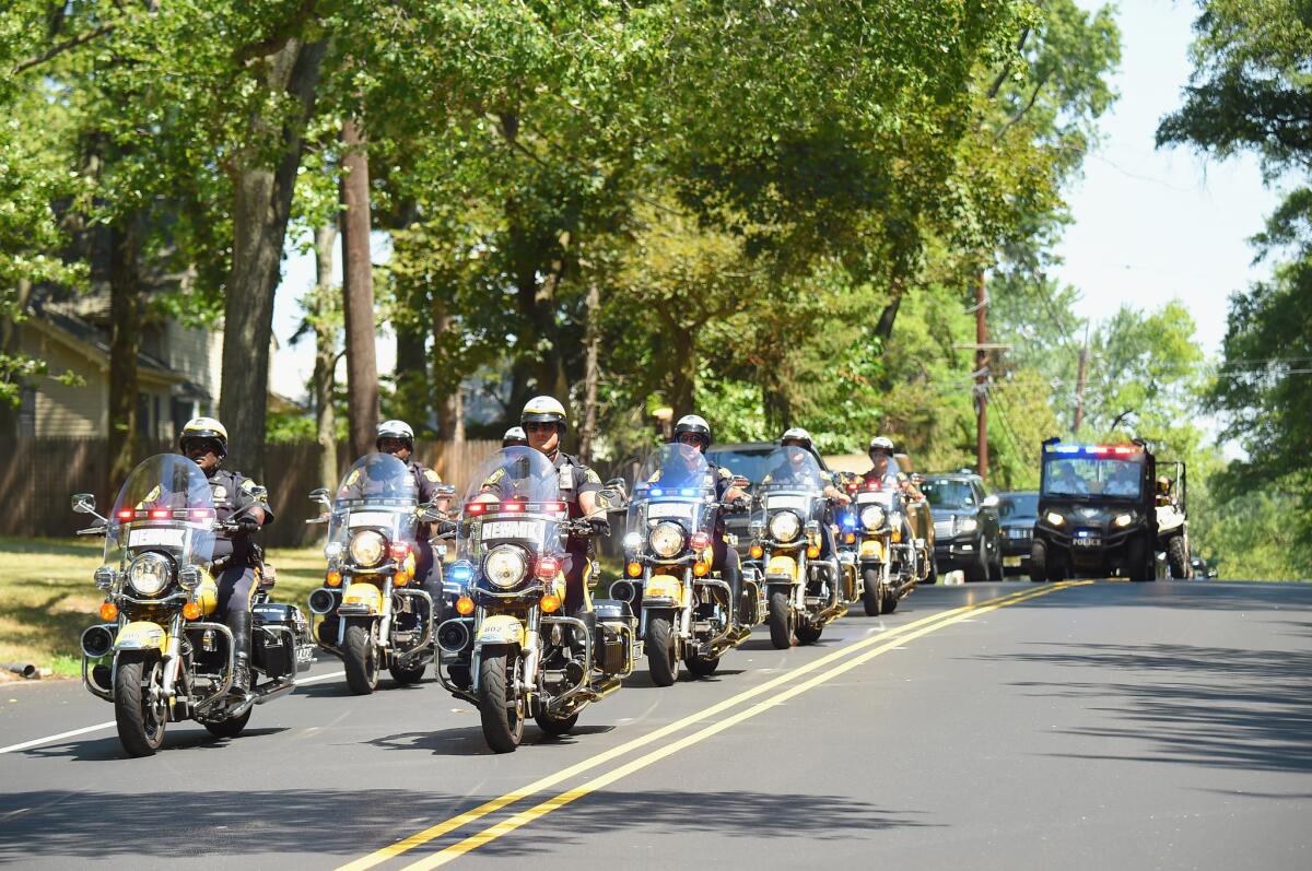 A police procession escorts a hearse containing Bobbi Kristina Brown's casket as it arrives at the Fairview Cemetery in Westfield, N.J., on Monday.