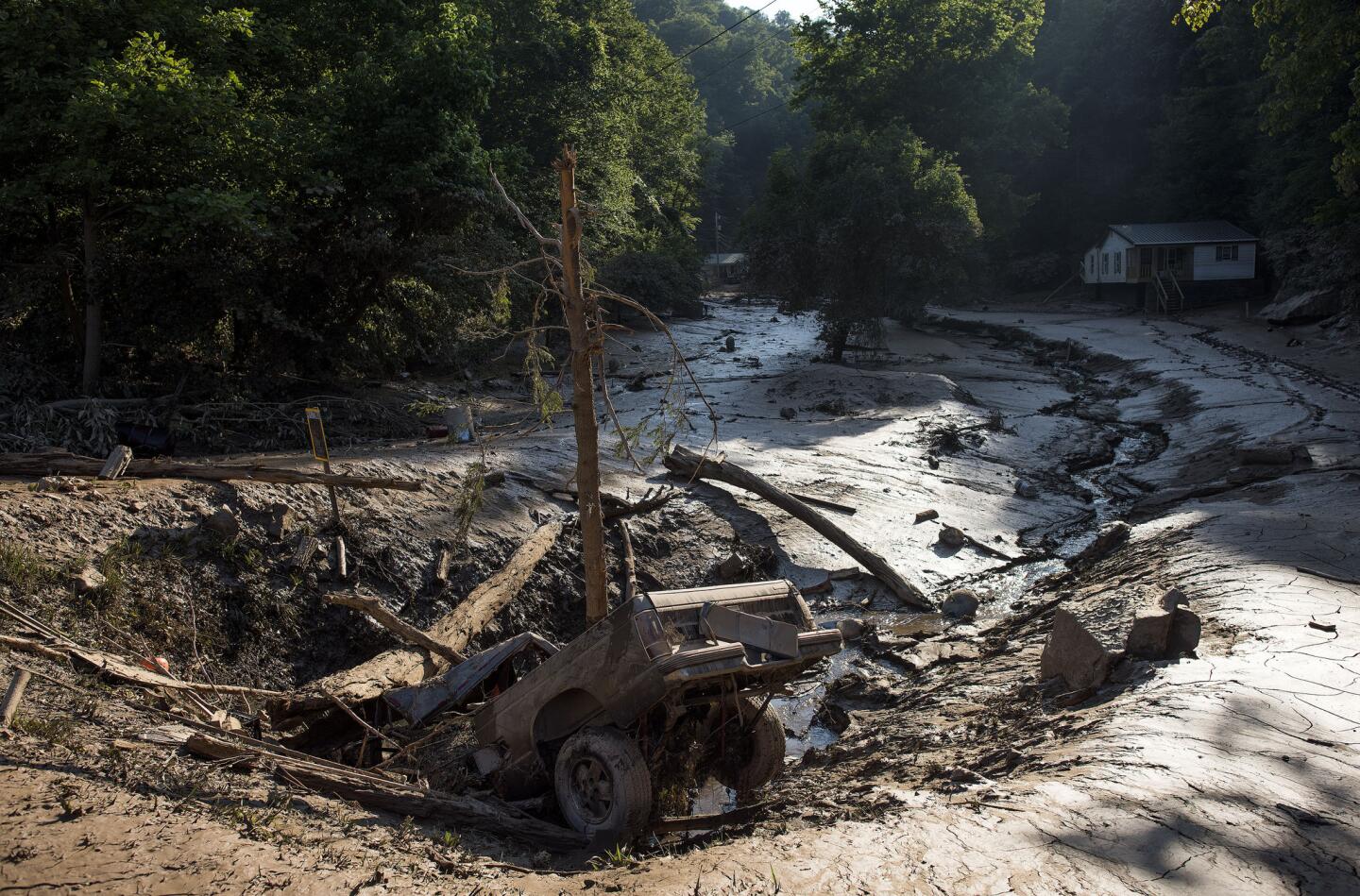 A truck lies in a hole amongst the mud after it was washed out of the driveway from the flooding on June 25, 2016, in Clendenin, West Virginia. T