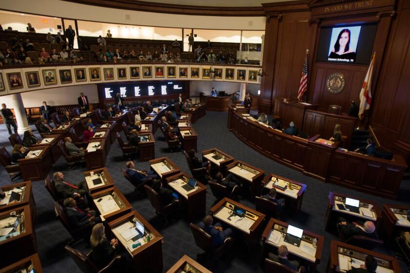 FILE - In this Feb. 21, 2018, file photo, the Florida Senate chamber is darkened while a slideshow shows each person killed in a shooting at Marjory Stoneman Douglas High School, at the state Capitol in Tallahassee, Fla. The Florida Senate spent hours debating a bill to increase school safety and restrict gun purchases in a rare Saturday session, March 3, that often turned into a debate on gun control and arming teachers in the aftermath of last month's Parkland school shootings. (AP Photo/Mark Wallheiser, File)