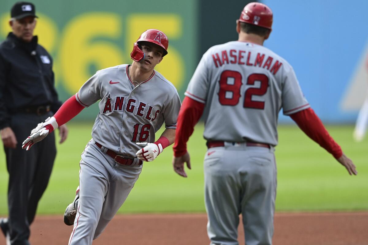 The Angels' Mickey Moniak is greeted by third base coach Bill Haselman after leading off the game with a homer May 13, 2023.