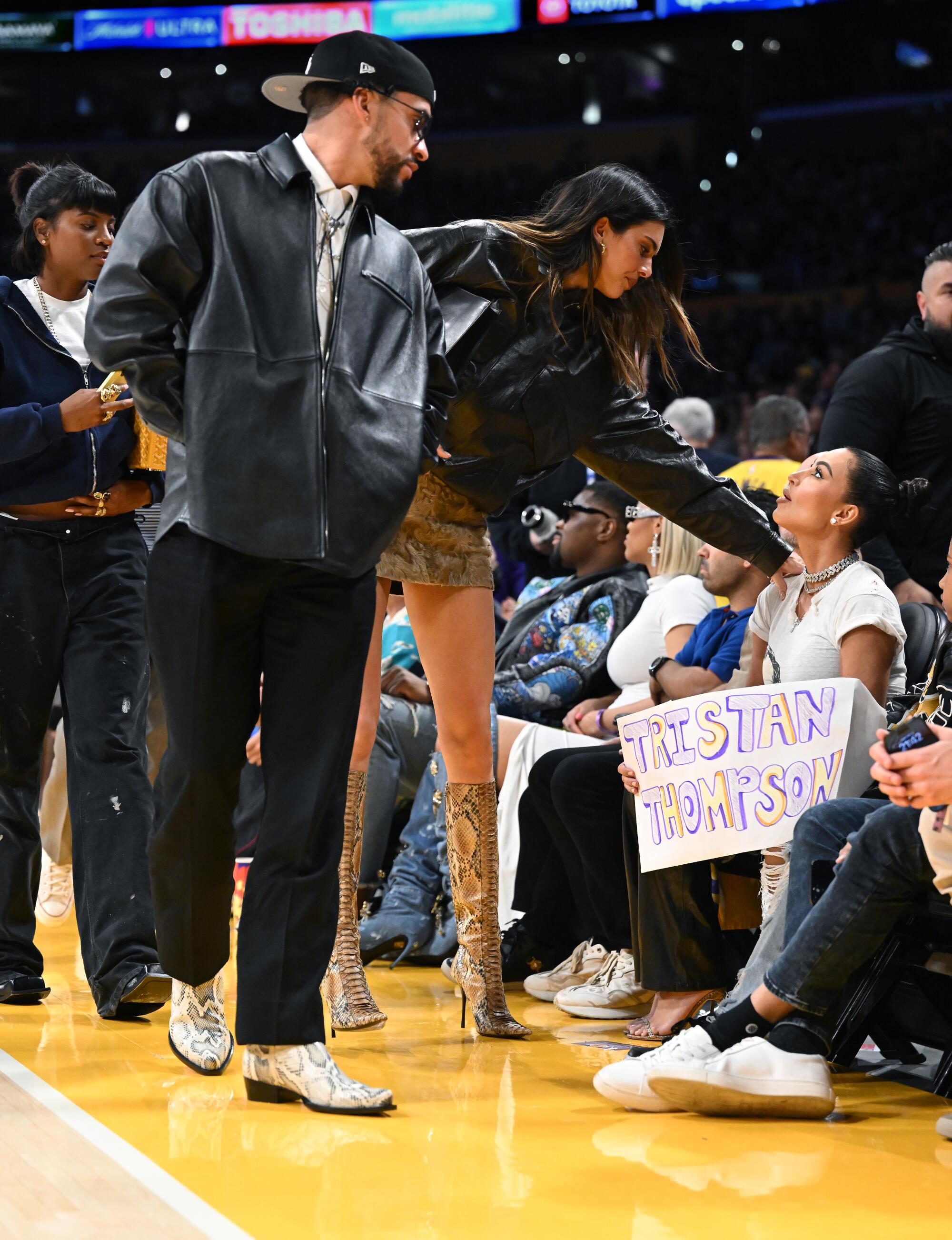 Kendall Jenner, center, sits courtside with Bad Bunny during the