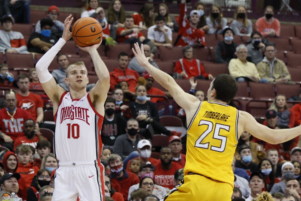 Ohio State's Justin Ahrens, left, shoots over Towson's Nicolas Timberlake during the second half of an NCAA college basketball game Wednesday, Dec. 8, 2021, in Columbus, Ohio. (AP Photo/Jay LaPrete)