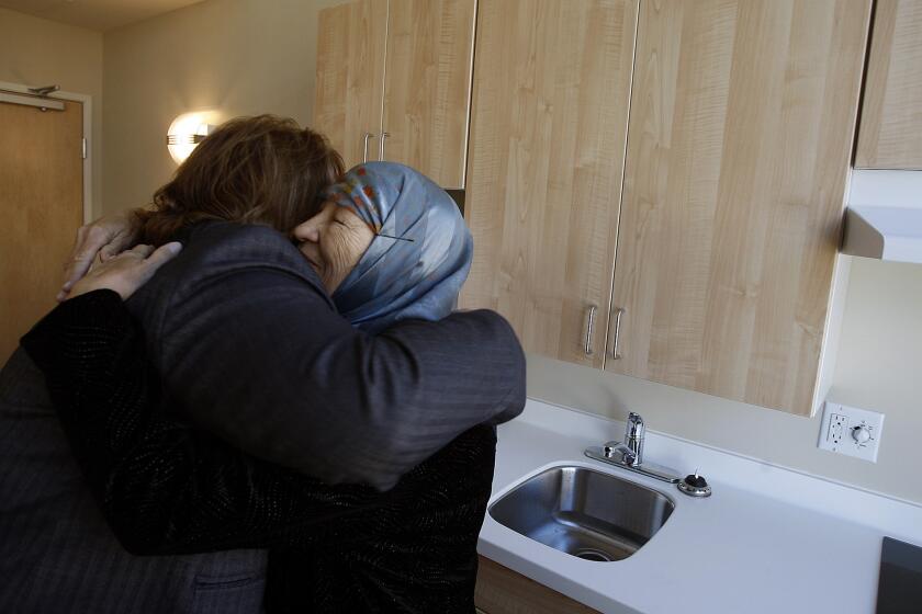 Lisa Watson, left, hugs Sofia Russell in Russell's new room in the Downtown Women's Center in Los Angeles in December 2010.