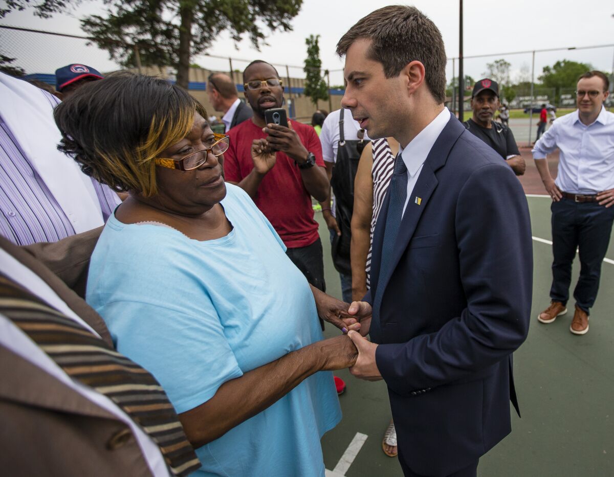 FILE - In this Wednesday, June 19, 2019 file photo, South Bend Mayor and Democratic presidential candidate Pete Buttigieg shares a moment with Shirley Newbill, mother of Eric Logan, during a gun violence memorial in South Bend, Ind. A federal judge has dismissed a wrongful death lawsuit filed by the family of Eric Logan who was fatally shot by a white South Bend police officer in a killing that snarled then-Mayor Pete Buttigieg's presidential campaign. (Michael Caterina /South Bend Tribune via AP)
