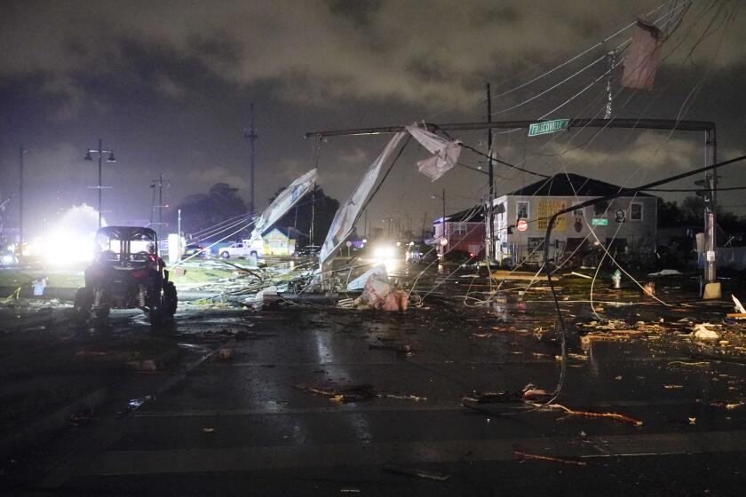 A debris lined street is seen in the Lower 9th Ward, Tuesday, March 22, 2022, in New Orleans, after strong storms moved through the area. (AP Photo/Gerald Herbert)