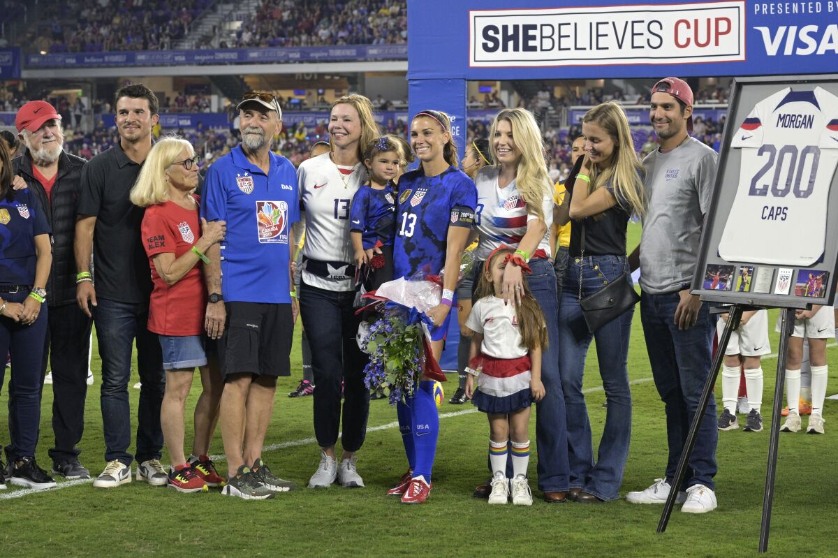 Alex Morgan holds her daughter while being honored for her 200th appearance for the U.S. women's national team.