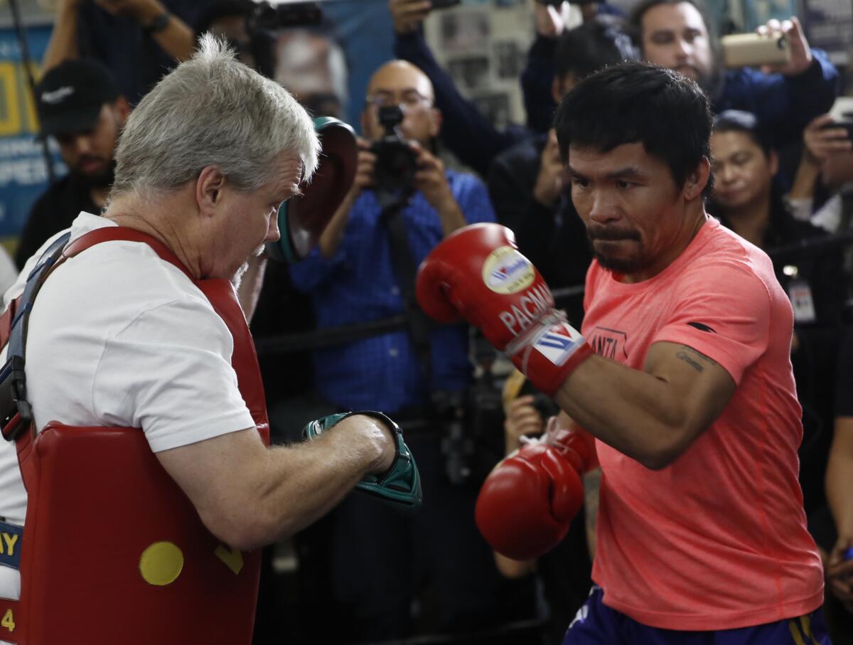 Manny Pacquiao, right, works out with trainer Freddie Roach at a boxing club in Los Angeles, Wednesday, Jan. 9, 2019. Pacquiao is scheduled to defend his WBA welterweight title against Adrien Broner on Jan. 19, 2019, in Las Vegas.